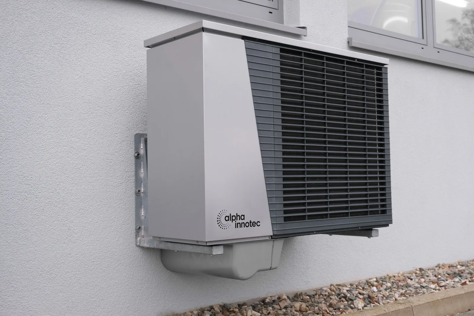 Outdoor heat pump unit installed beside a residential structure, representative of pool and spa heating equipment